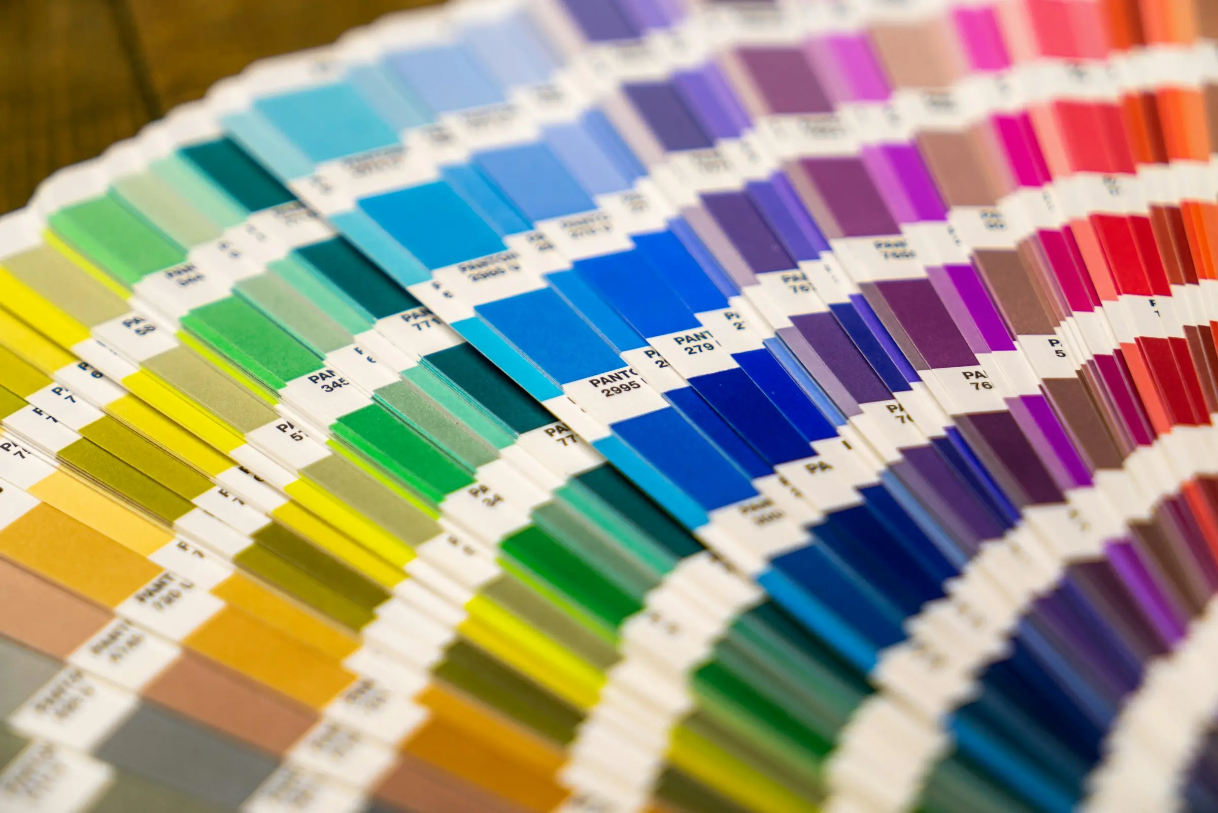 A colour swatch fan opened across a printed sheet.
